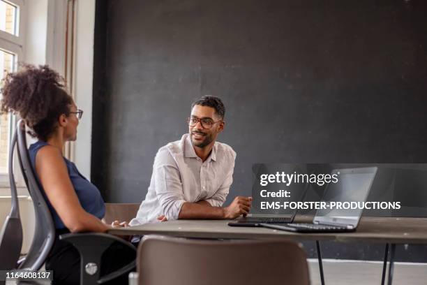 businessman looking at female manager in her modern office - showing respect fotografías e imágenes de stock