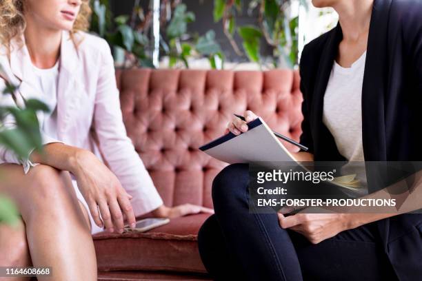 two woman are sitting on a old fashioned sofa - alternative therapy stock pictures, royalty-free photos & images