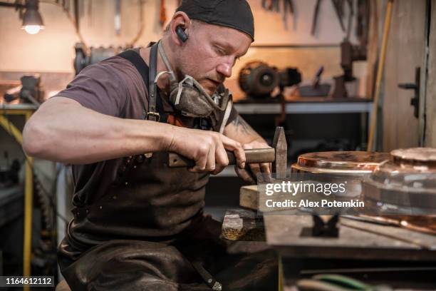 manual worker wearing a protective apron checking the brass details in the workshop - brocade stock pictures, royalty-free photos & images