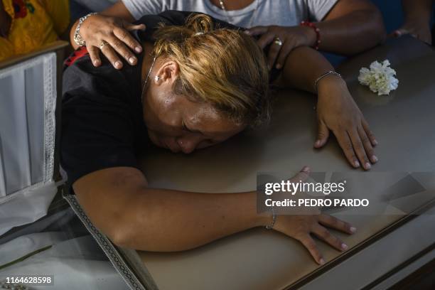 Vanessa Blas cries over the coffin of her husband Erick Hernandez, DJ at the Caballo Blanco bar and one of the 28 victims of the attack at the place,...