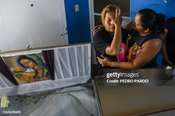 Vanessa Blas is comforted next to the coffin of her husband Erick Hernandez, DJ at the Caballo Blanco bar and one of the 28 victims of the attack at...