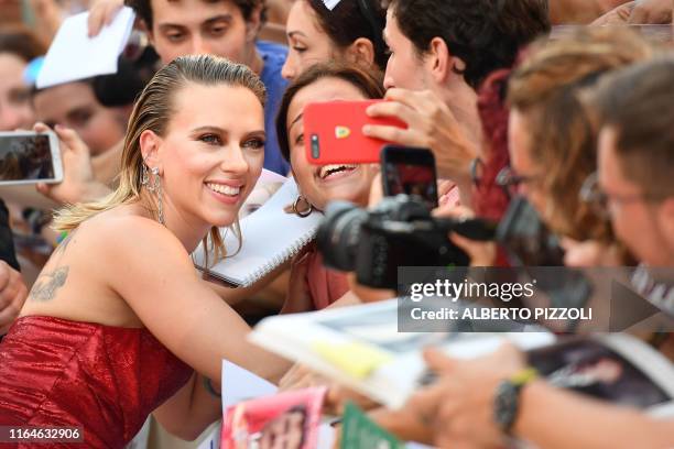 Actress Scarlett Johansson poses for selfie photos with fans as she arrives on August 29, 2019 for the screening of the film "Marriage Story" during...