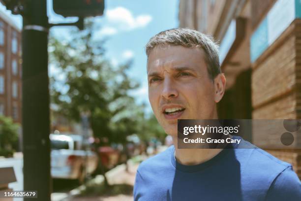 man surveys scene in downtown district - staring stock pictures, royalty-free photos & images