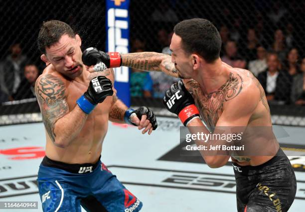 Max Holloway punches Frankie Edgar in their UFC featherweight championship bout during the UFC 240 event at Rogers Place on July 27, 2019 in...