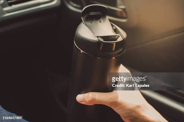 drinking a hot coffee on reusable coffee mug while inside the car - drinks flask stock pictures, royalty-free photos & images