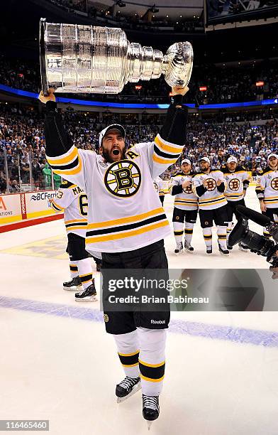 Patrice Bergeron of the Boston Bruins celebrates by hoisting the Stanley Cup after defeating the Vancouver Canucks 4-0 in Game Seven of the 2011 NHL...