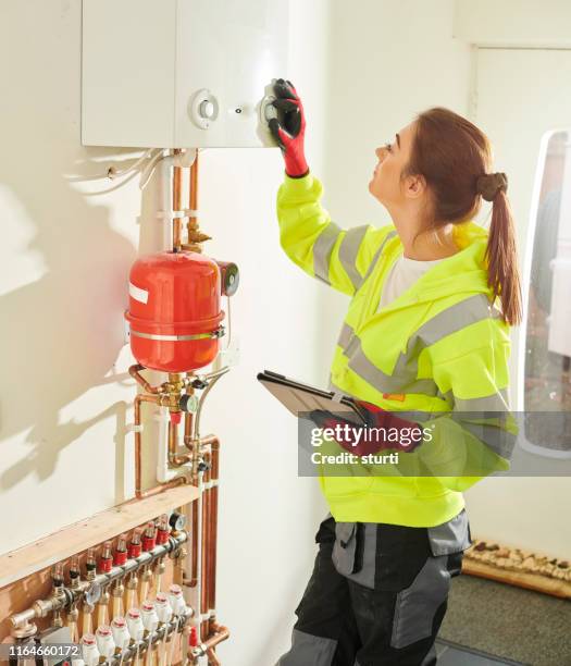vrouwelijke verwarmings ingenieur - boiler engineer stockfoto's en -beelden