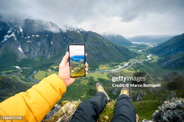 personal perspective of man photographing romsdalen valley, norway - facebook feet stock pictures, royalty-free photos & images