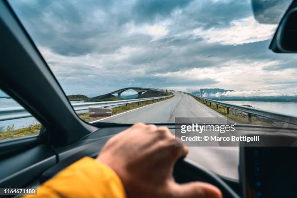 personal perspective of man driving along the atlantic ocean road, norway - vue subjective main photos et images de collection