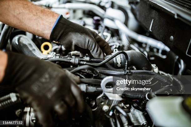 close up of a mechanic examining car pump in a workshop. - diesel motor stock pictures, royalty-free photos & images