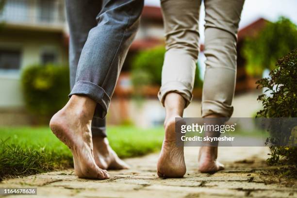 在後院赤腳行走的無法辨認的夫婦的特寫鏡頭。 - barefoot men 個照片及圖片檔
