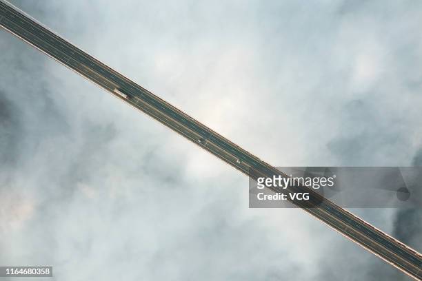 An aerial view of the Aizhai Suspension Bridge above the clouds on July 27, 2019 in Aizhai, Hunan Province of China. The Aizhai Suspension Bridge...