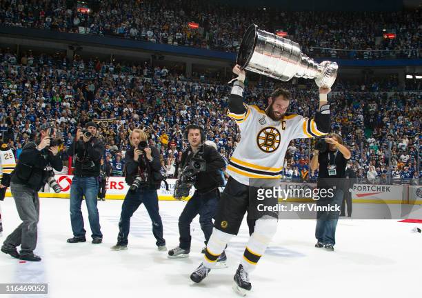 Photographers surround Zdeno Chara of the Boston Bruins as he celebrates with the Stanley Cup after winning Game Seven of 2011 NHL Stanley Cup Final...