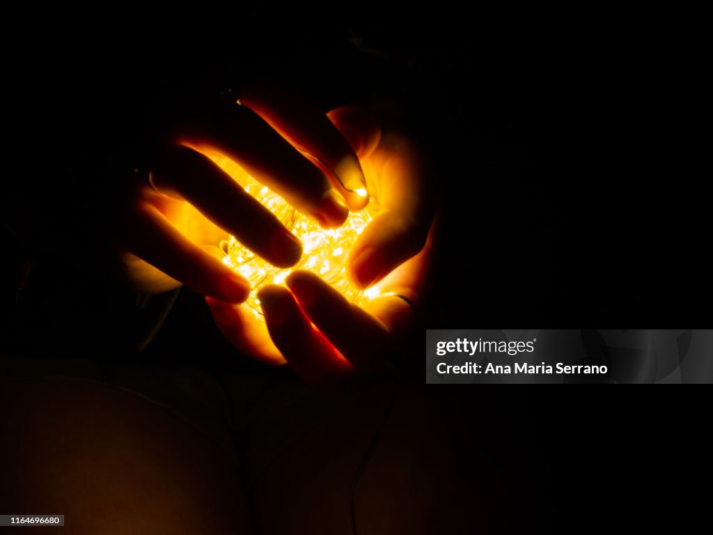 Fairy lights illuminating a woman's hands