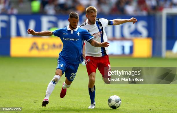 Aaron Hunt of Hamburg challenges Marcel Heller of Darmstadt during the Second Bundesliga match between Hamburger SV and SV Darmstadt 98 at...