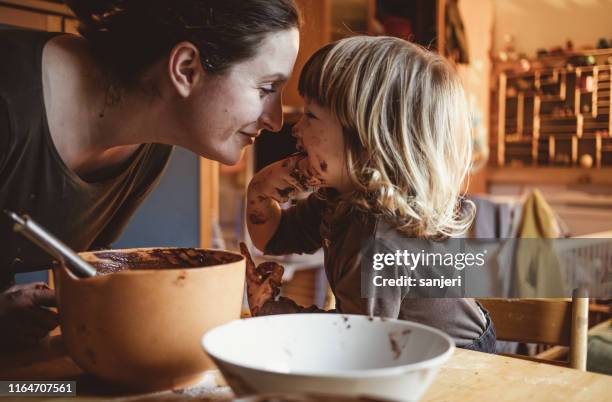 kleinkind macht kekse mit seiner mutter - chocolat stock-fotos und bilder