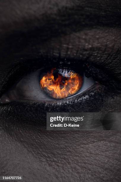 close up photo of female eye with fire reflection - demon stock pictures, royalty-free photos & images