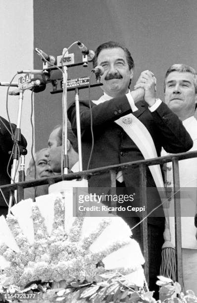 Newly elected President of Argentina Raul Alfonsin makes the gesture of the shaking hands, used in his campaign, on the balcony of the town council...
