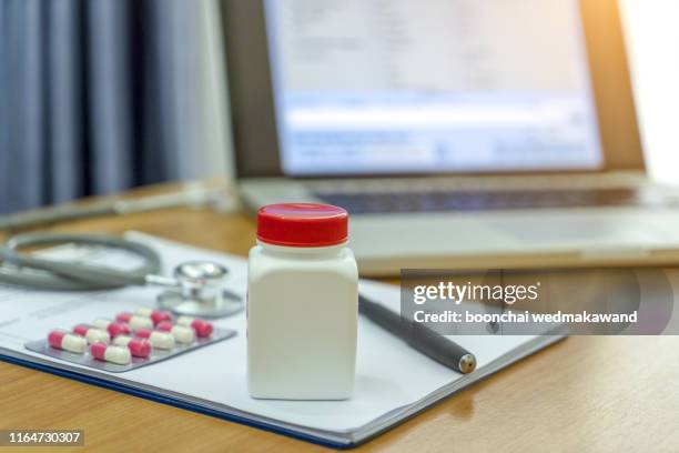 patient chart with stethoscope and medical supplies in background. - stethoscope pills stock pictures, royalty-free photos & images