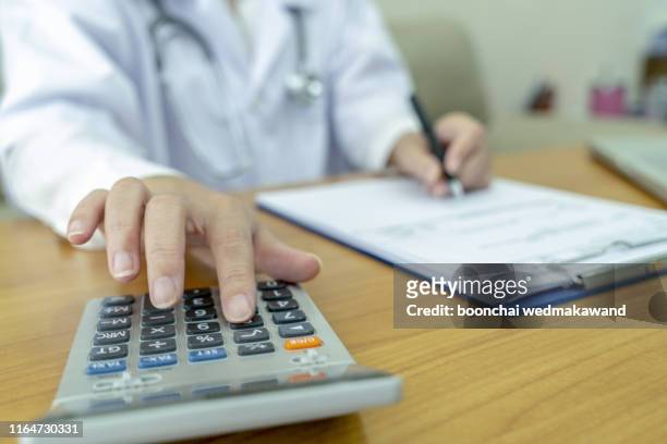 healthcare costs and fees concept.hand of smart doctor used a calculator for medical costs in modern hospital. - price calculator foto e immagini stock