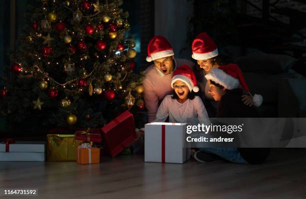 excited family opening christmas gifts at home - kid with christmas tree stock pictures, royalty-free photos & images