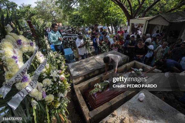 Relatives and friends attend the funeral of a victim of the attack at the Caballo Blanco bar , during the funeral at a cemetery in Coatzacoalcos,...