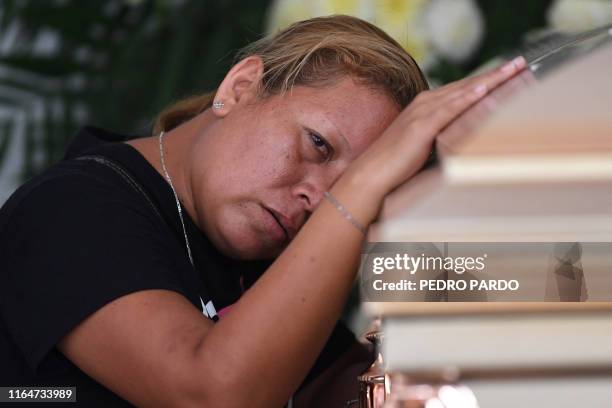 Woman mourns as she leans against the coffin of a victim of the attack at the Caballo Blanco bar , during a funeral service at a cemetery in...
