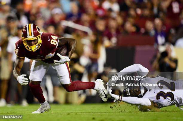Darvin Kidsy of the Washington Redskins avoids the tackle of DeShon Elliott of the Baltimore Ravens in the second quarter during a preseason game at...