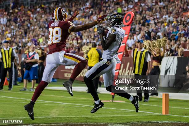Jaleel Scott of the Baltimore Ravens catches a pass for a touchdown against Deion Harris of the Washington Redskins during the first half of a...