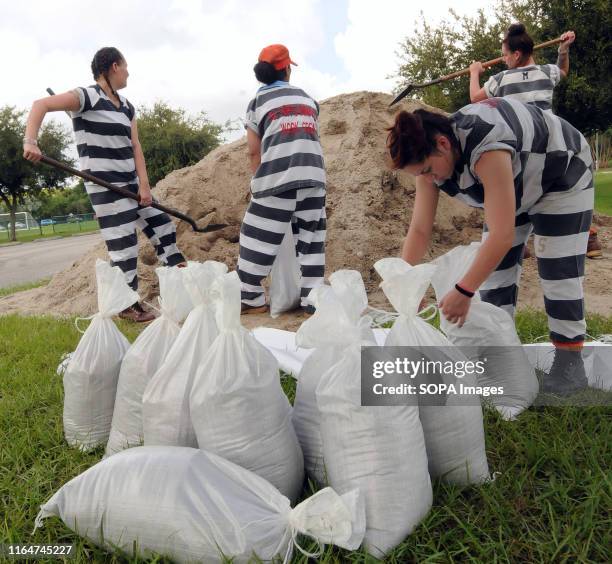 Supervised work crew of female jail prisoners fills sandbags for distribution to local residents in preparation for the arrival of Hurricane Dorian...