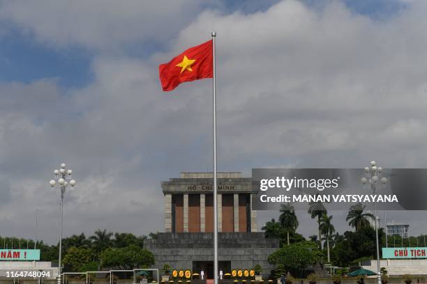 This photograph taken on August 28, 2019 shows a Vietnamese national flag fluttering in the wind outside the Ho Chih Minh mausoleum in Hanoi. -...