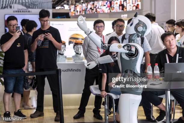 Attendees gather at a demonstration of the CloudMinds Technology Inc. XR-1 commercial humanoid service robot at the World Artificial Intelligence...