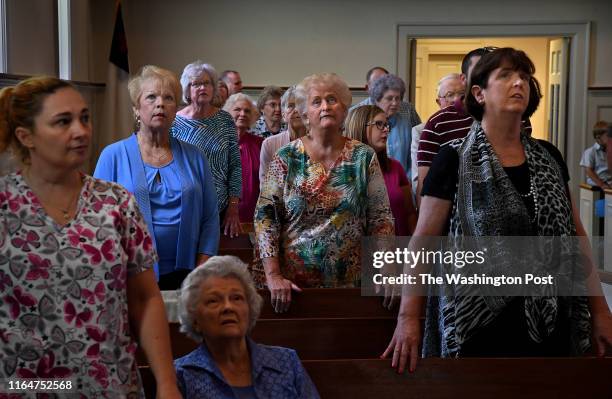 - Members of the First Baptist Church of Luverne follow a Bible verse that was projected on a screen above the pulpit during the Sunday sermon. - The...