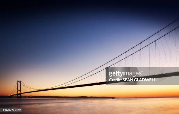 humber bridge at sunset - humber bridge stockfoto's en -beelden