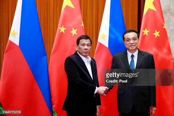 Philippine President Rodrigo Duterte and Chinese Premier Li Keqiang shake hands during their meeting at the Great Hall of the People on August 30,...
