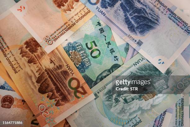 New yuan banknotes are seen on a table at a bank counter in Hangzhou in China's eastern Zhejiang province on August 30 as the People's Bank of China...