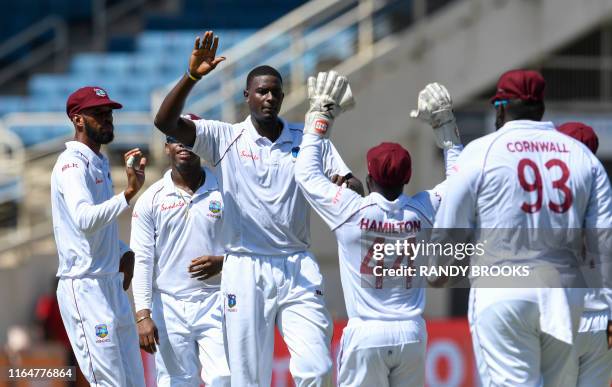 Jason Holder and Roston Chase of West Indies celebrate the dismissal of KL Rahul of India during day 1 of the 2nd Test between West Indies and India...