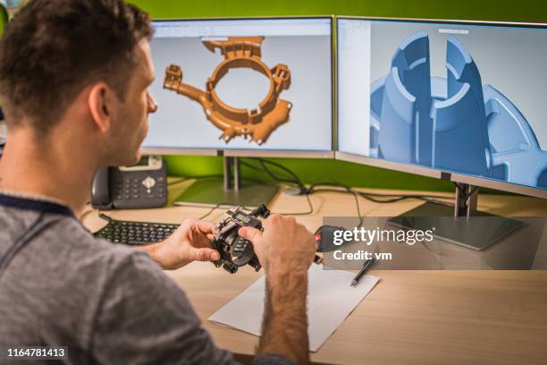 ingeniero examinando la pieza de la máquina mientras hace un modelo 3d de la misma - profesional de diseño fotografías e imágenes de stock