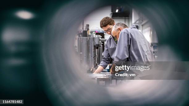 ingenieure, die eine maschine reparieren - ingenieur stock-fotos und bilder