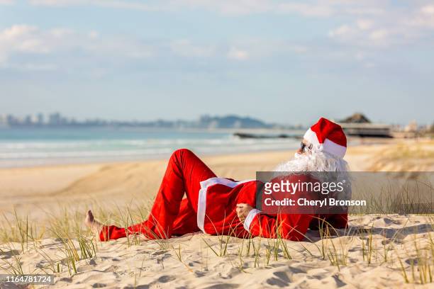 summer santa lying on the beach - christmas australia ストックフォトと画像
