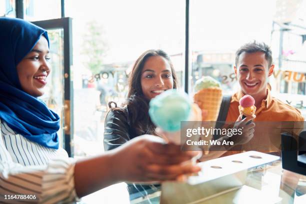 friends buying ice cream in ice cream parlour - ice cream parlour stock pictures, royalty-free photos & images