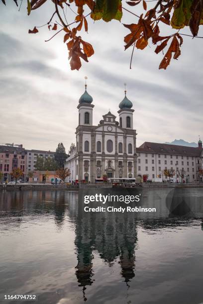 jesuit church reflected in water in lucerne, switzerland - jesuit stock-fotos und bilder