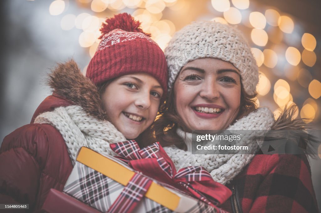 Happy mother and daughter holding Christmas presents