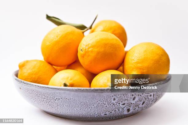 bowl of lemons - blue bowl stock-fotos und bilder