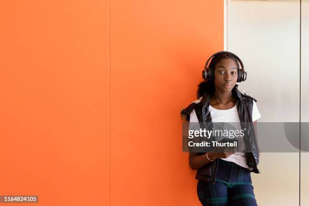 african australian teenage girl listening to music under headphones - hoodie headphones stock pictures, royalty-free photos & images