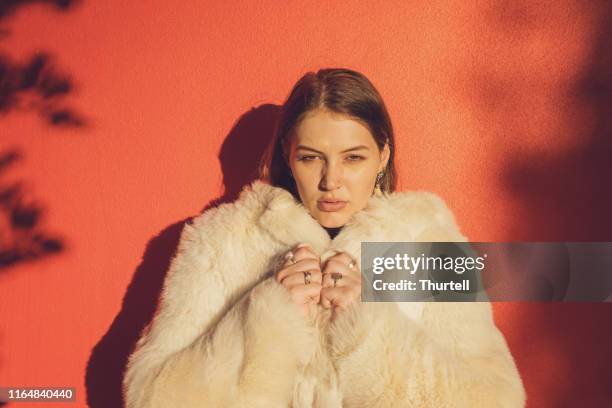 young woman wearing fake fur coat - fake fur stock pictures, royalty-free photos & images