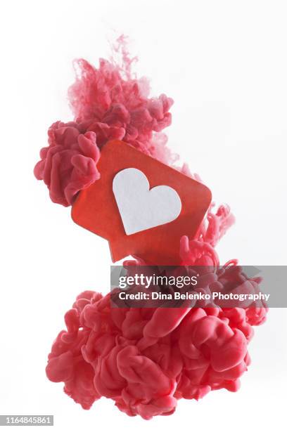 colorful cloud around a red like icon with a heart. dissolving in social media concept. red paint on a white background with copy space - social media like stock pictures, royalty-free photos & images