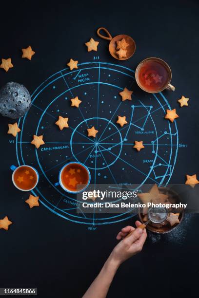 stargazers teatime with astrological and astronomical symbols. chalk map of the starry sky. creative food photography flat lay - sternzeichen stock-fotos und bilder