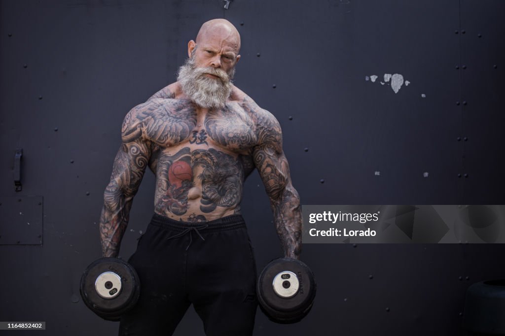 Tätowierte Senior Mann während Gym Training