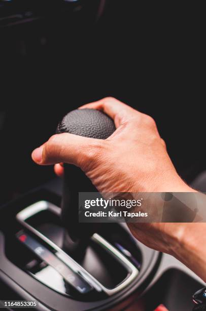 a young man is holding an automatic gear stick - gears stick imagens e fotografias de stock